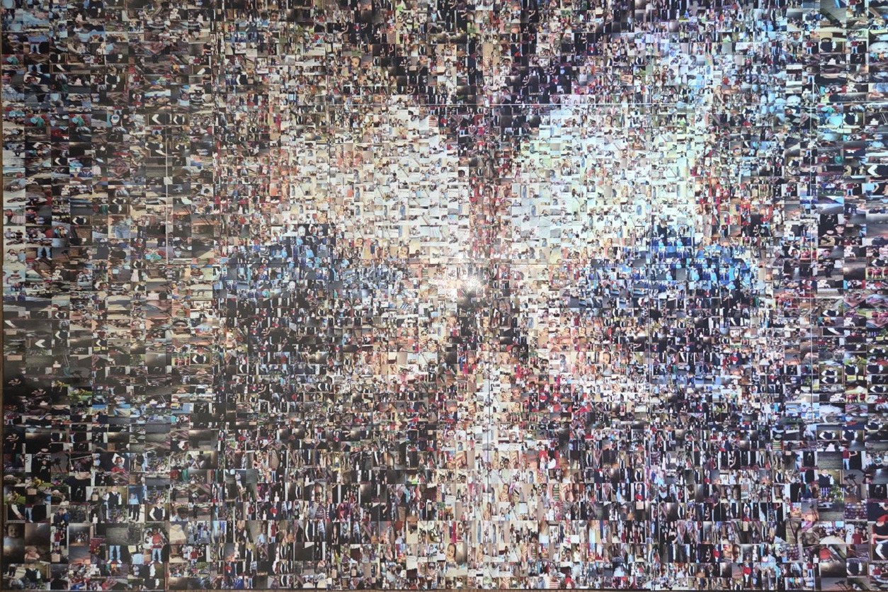 Straight-on photograph of Inheritance of Light, with two faces and the family tree formed from many smaller photographs