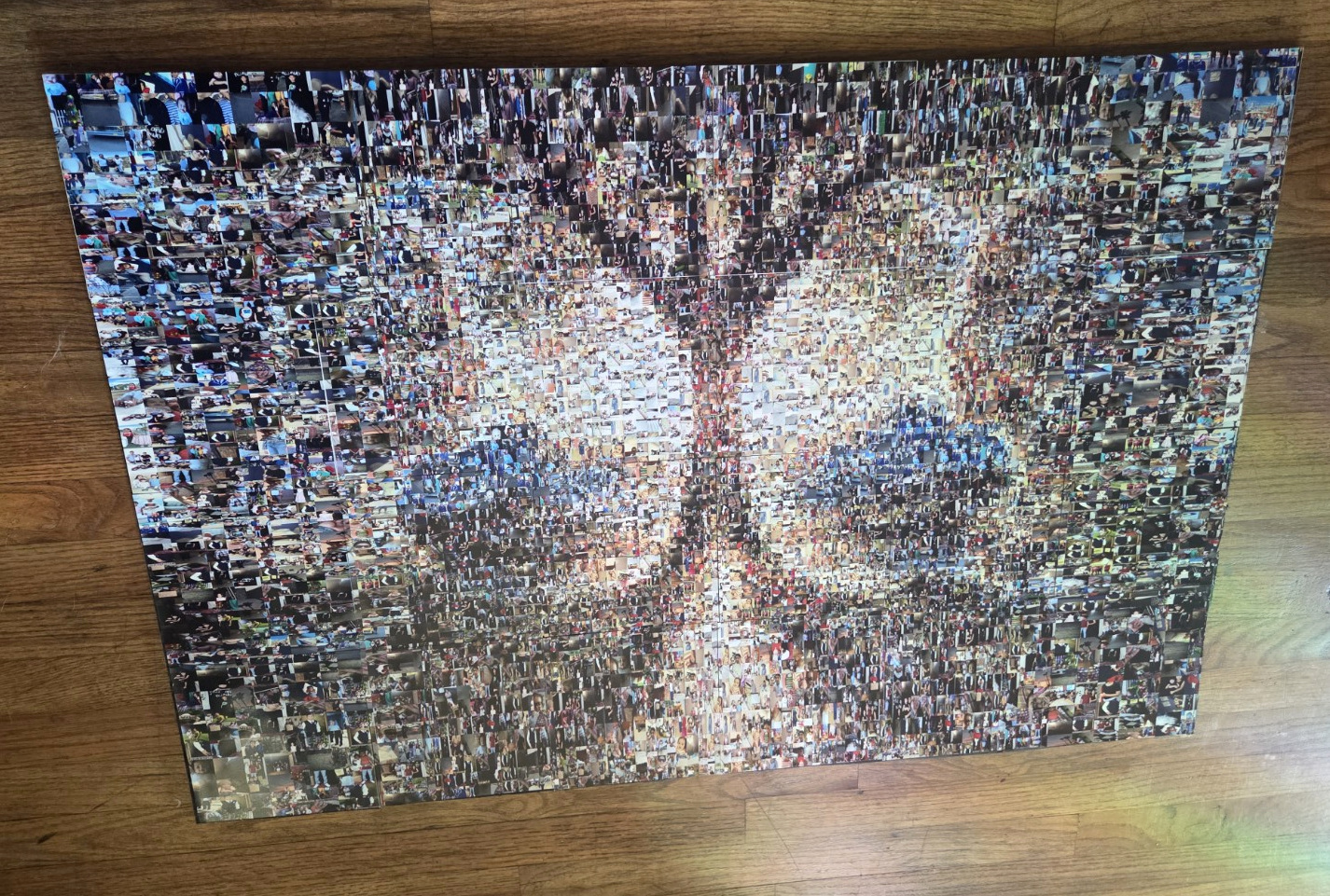 Angled view of the real photographic mosaic, with natural rainbow-colored light on the wooden floor beside it